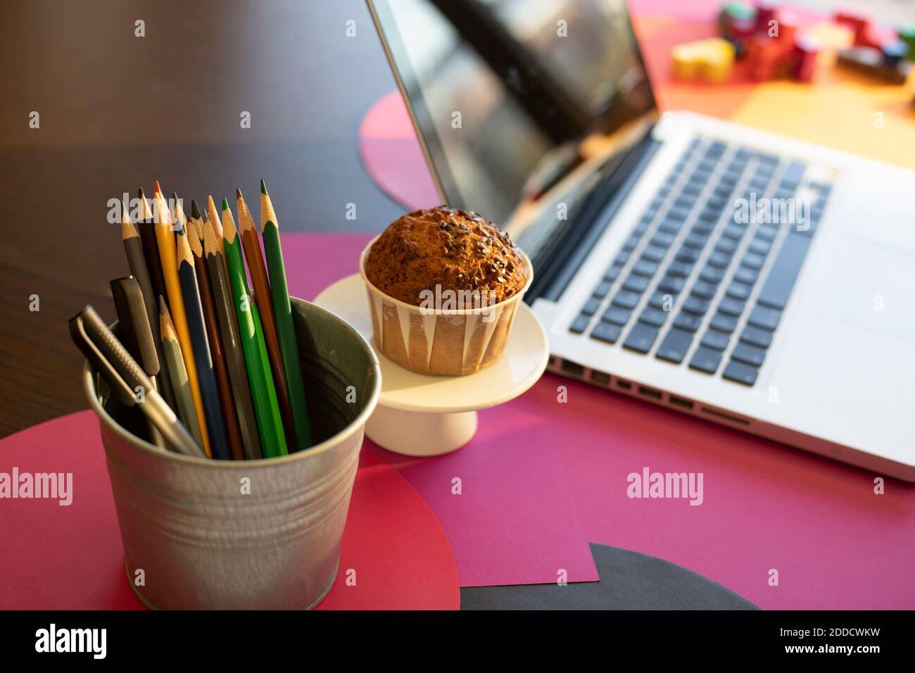 High-Angle-Ansicht von Schreibgerät, Kuchen und Laptop auf dem Tisch zu Hause Stockfoto