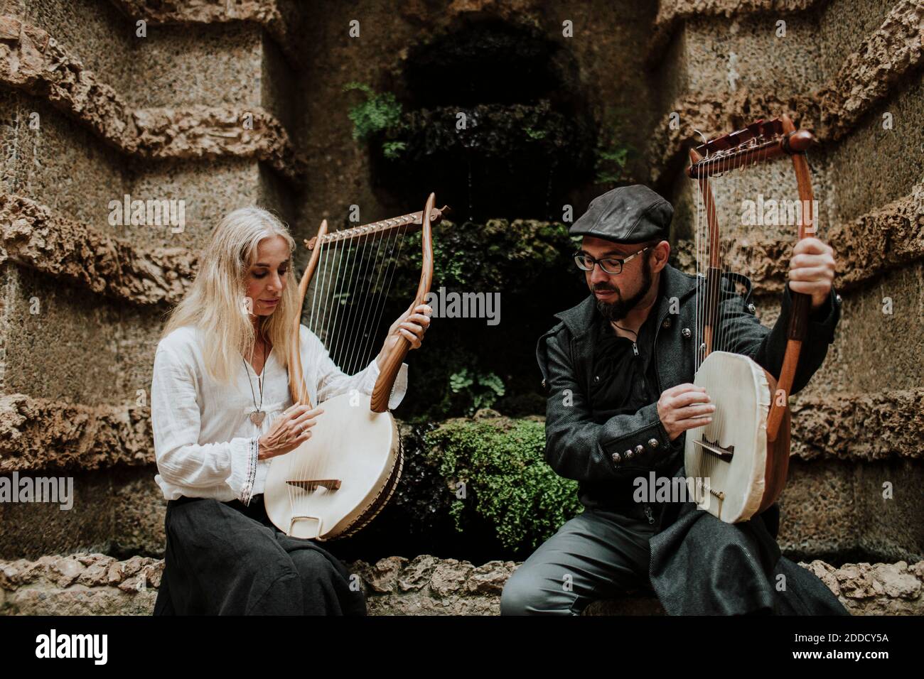 Mann und Frau spielen Lyra-Instrument im Park Stockfoto
