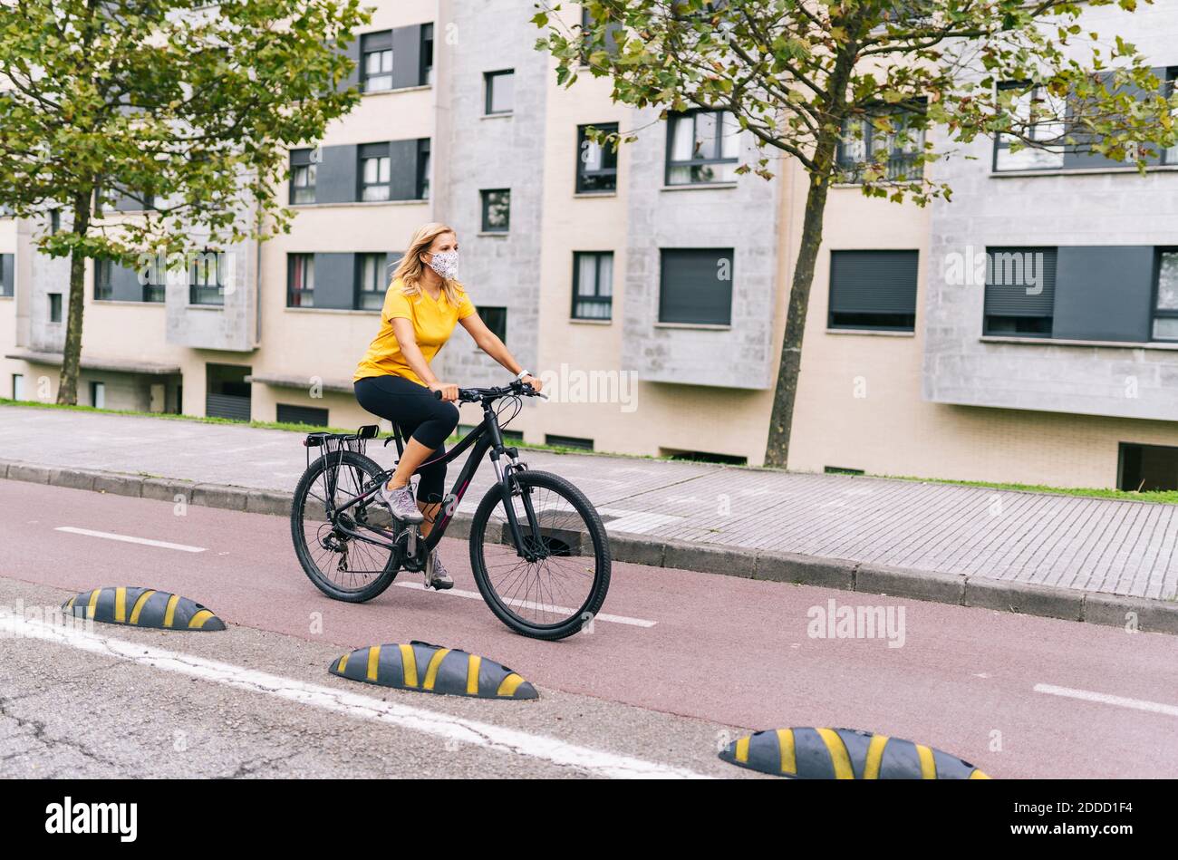 Reife Frau, die während der COVID-19 auf der Fahrradstraße in der Stadt unterwegs ist Stockfoto