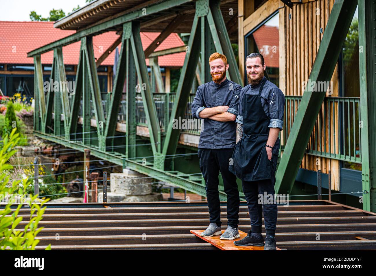 Brettspiele: Alexander Gläser (links) und Marcel Meining stehen dort, wo bald die offene Küche des Baronesse-Menüs gebaut wird. Ein Restaurant mit rund 25 Sitzplätzen, einem streng regionalen Konzept und einem coolen Industriedesign. Das Gästezimmer ist das verglaste Interieur einer Stahlbrücke über den Main in Sonderhofen, Deutschland Stockfoto