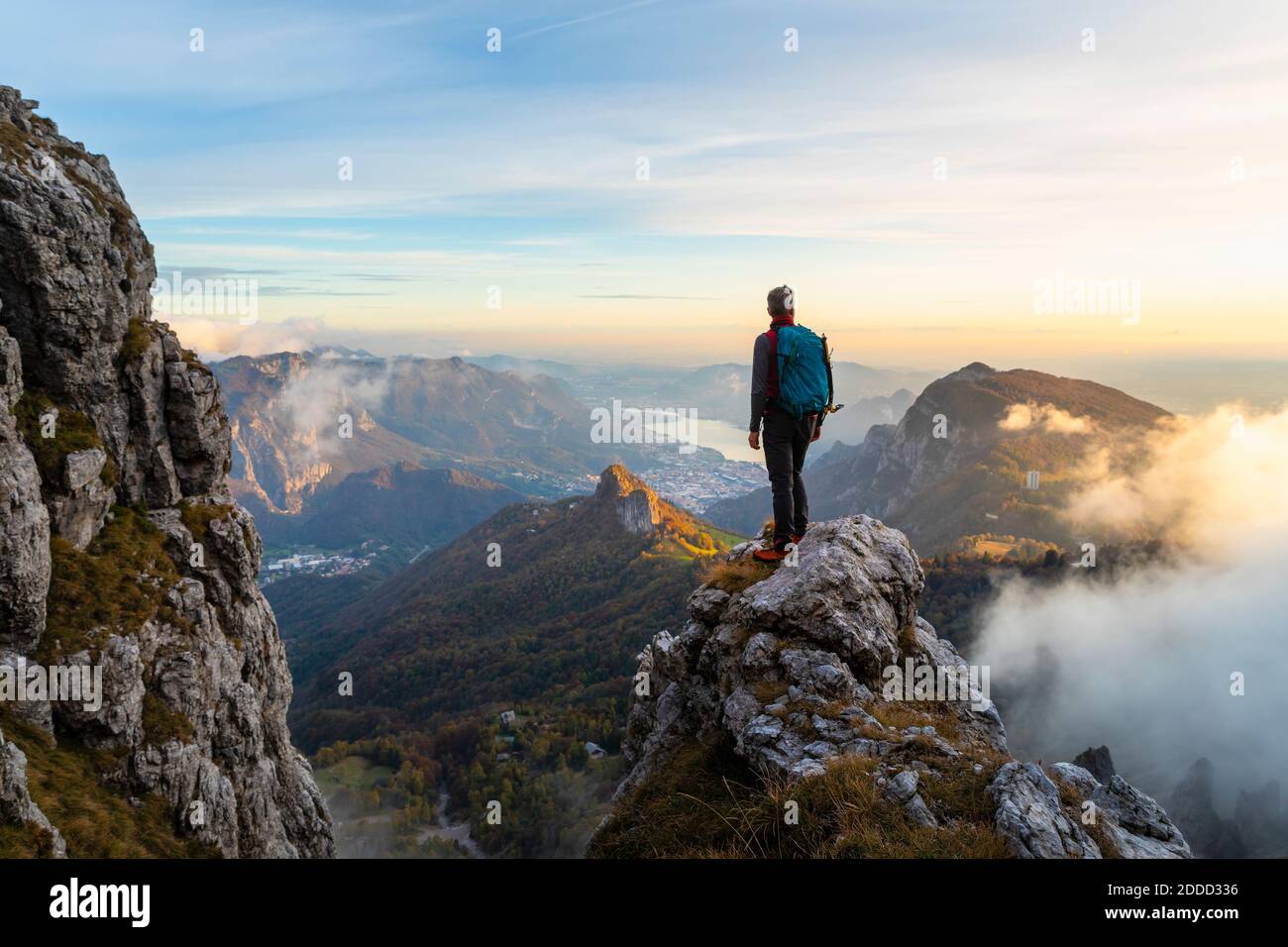 Nachdenklicher Wanderer mit Blick auf die Bergamasker Alpen, Italien, während er auf dem Berggipfel steht Stockfoto