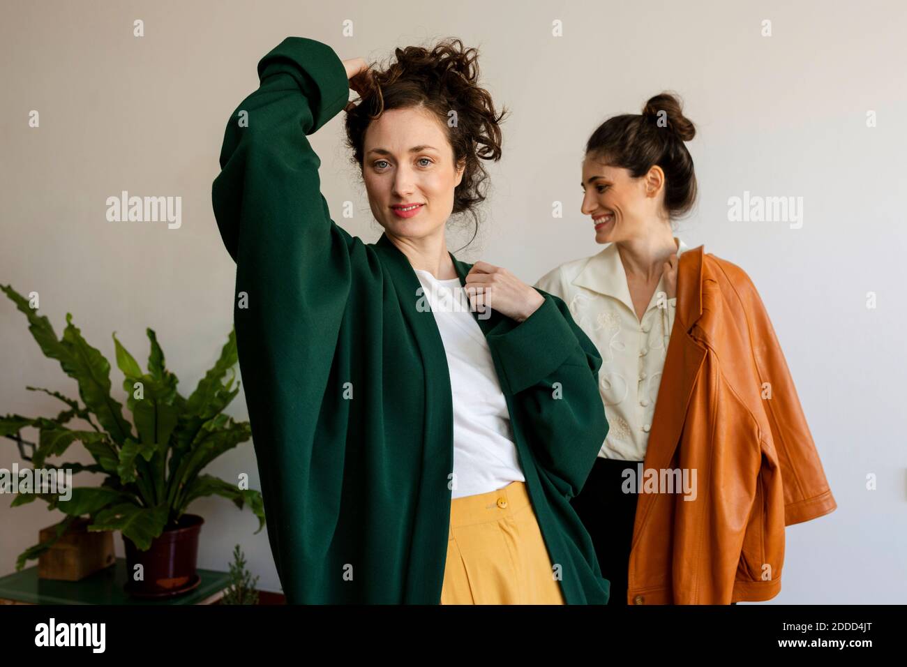 Schöne Frau mit Hand im Haar stehend mit lächelndem Weibchen Modell zu Hause Stockfoto Schöne Frau mit Hand im Haar stehend mit lächelndem Weibchen Modell zu Hause Stockfoto