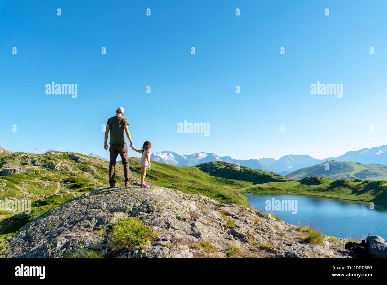 Vater und Tochter stehen auf einem Felsobjekt und betrachten es Gegen klaren Himmel Stockfoto