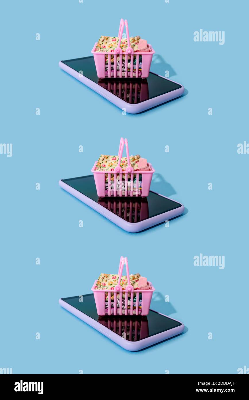 Reihe von Mini-Einkaufskörbe auf der Smart liegen Telefone Stockfoto