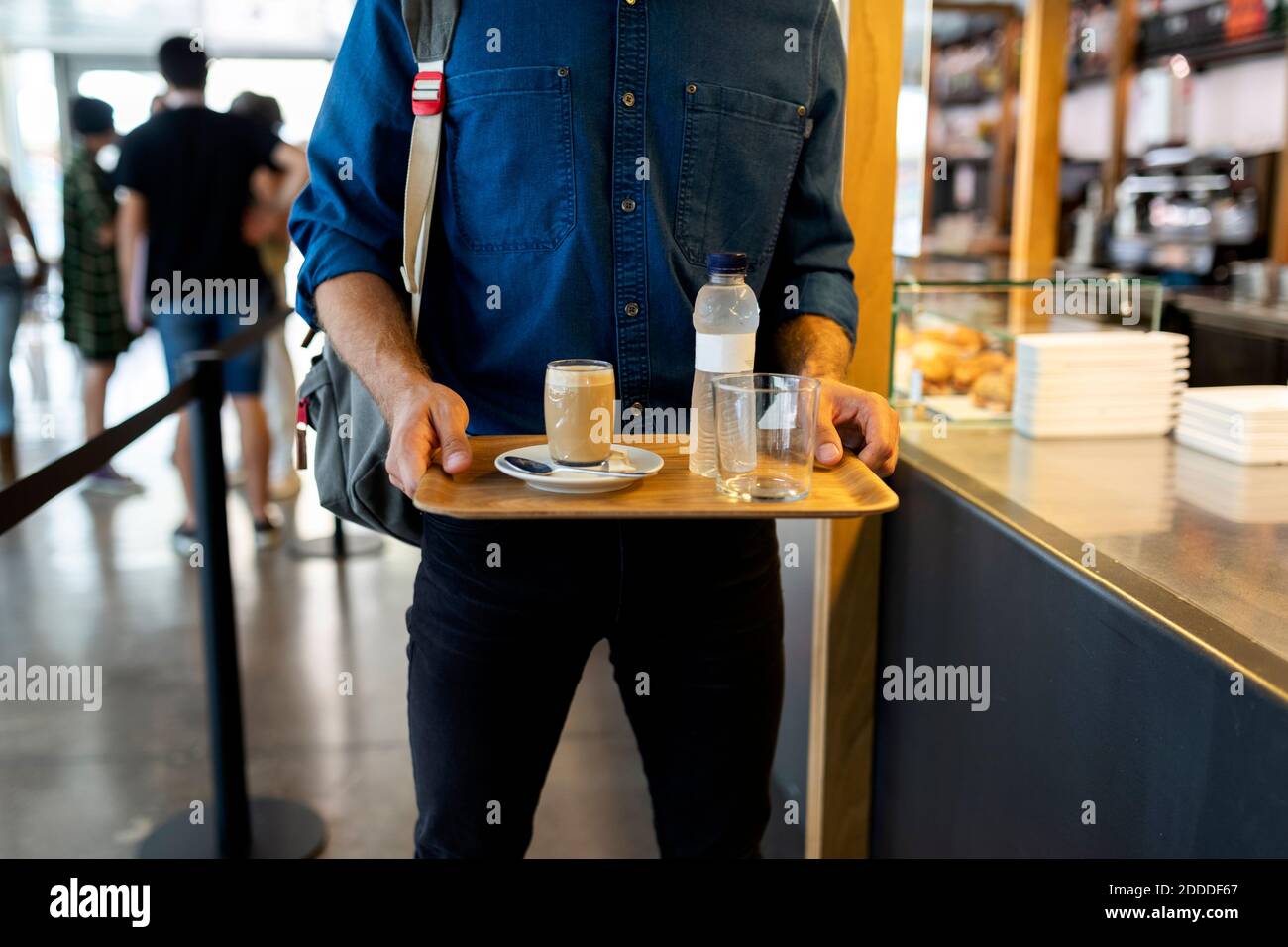Geschäftsmann mit erfrischenden Getränken auf dem Tablett im Café Stockfoto