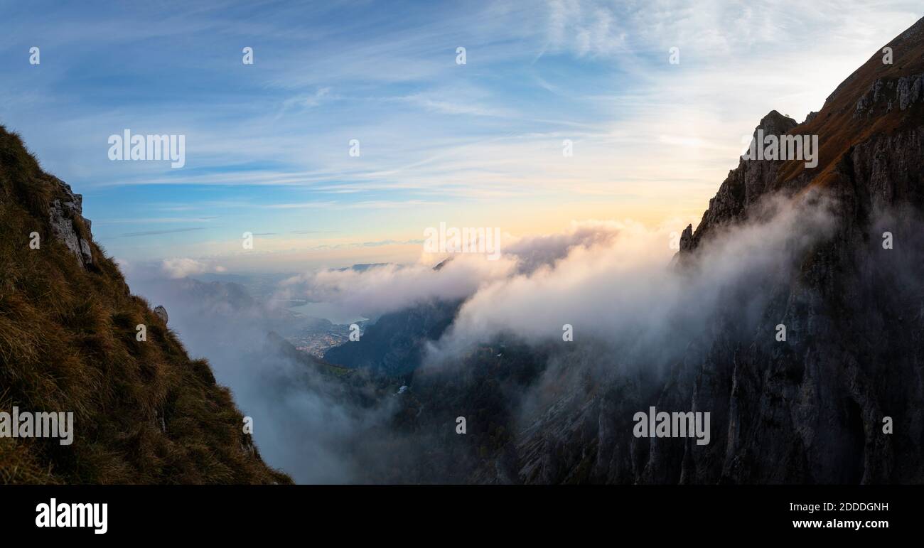 Idyllische Aufnahme von Bergen bedeckt von Wolken während Sonnenaufgang in Bergamasque Alpen, Italien Stockfoto