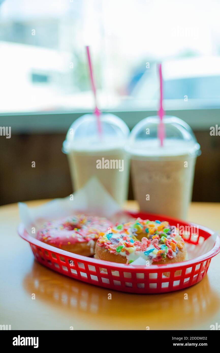 Milchshakes und Donuts auf dem Kaffeetisch Stockfoto