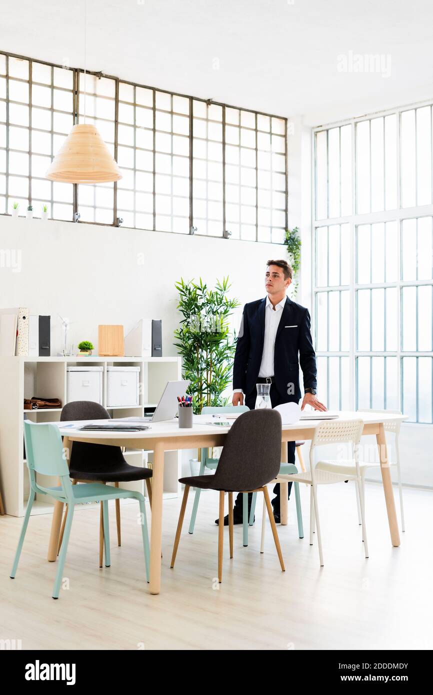 Junge männliche Unternehmer wegschauen, während die Planung Strategie am Schreibtisch Am Arbeitsplatz Stockfoto