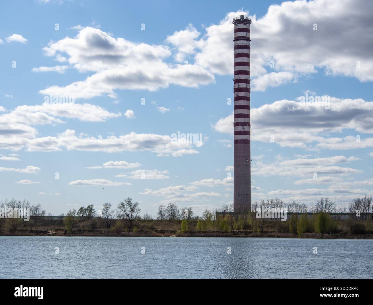 Alte Heizungsanlage Kamin. Ein Industriekamin gegen einen leicht bewölkten Himmel. Stockfoto