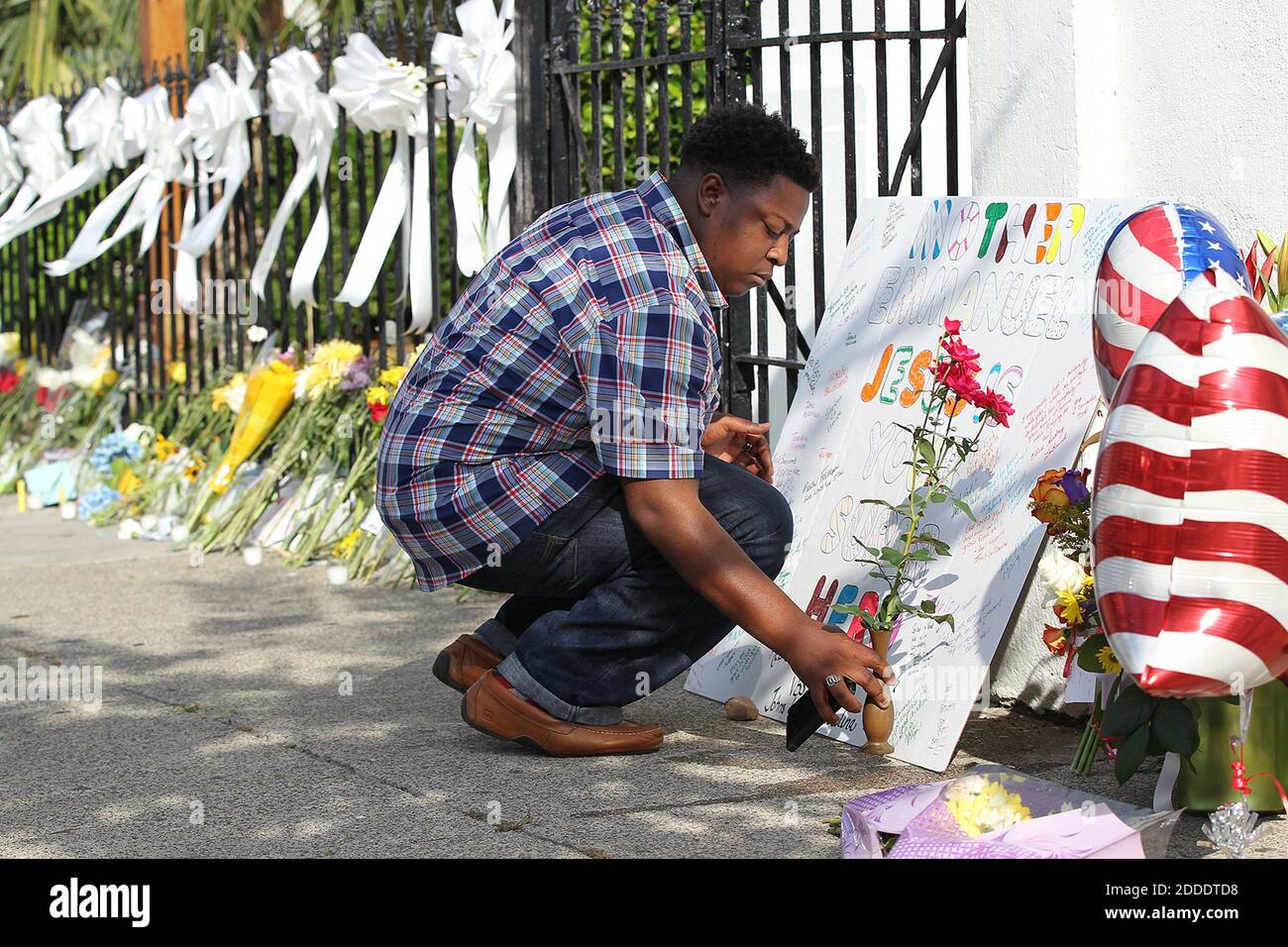 KEIN FILM, KEIN VIDEO, KEIN Fernsehen, KEIN DOKUMENTARFILM - Jermaine Jenkins, 25, legt ein Schild und ein paar Blumen auf dem 'Mutter' Emanuel A.M.E. Kirche am Freitag, 19. Juni 2015, in Charleston, SC, USA. Foto: Curtis Compton/Atlanta Journal-Constitution/TNS/ABACAPRESS.COM Stockfoto