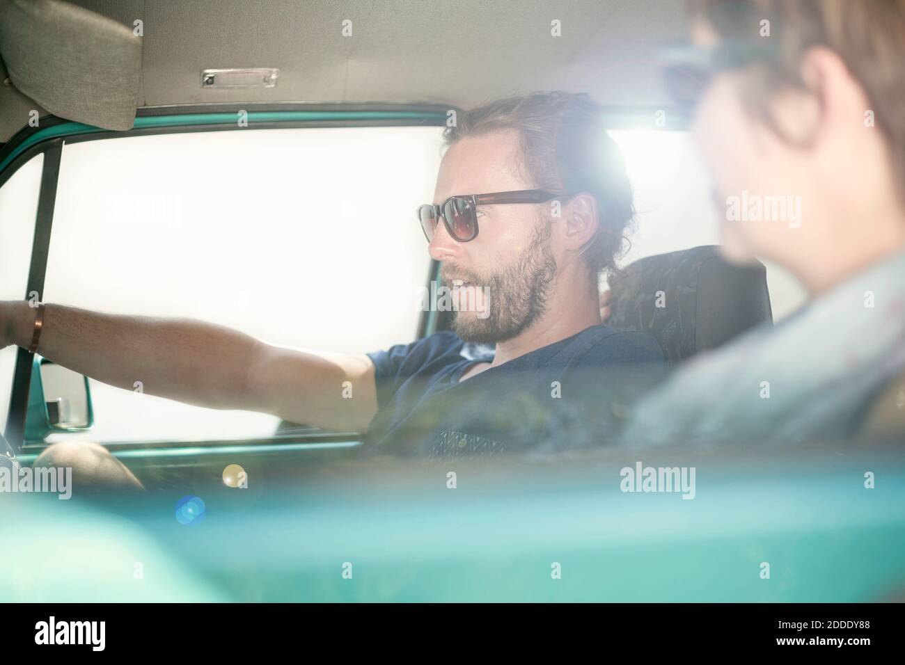 Lächelndes Paar, das während der Fahrt im Auto sitzt Stockfoto