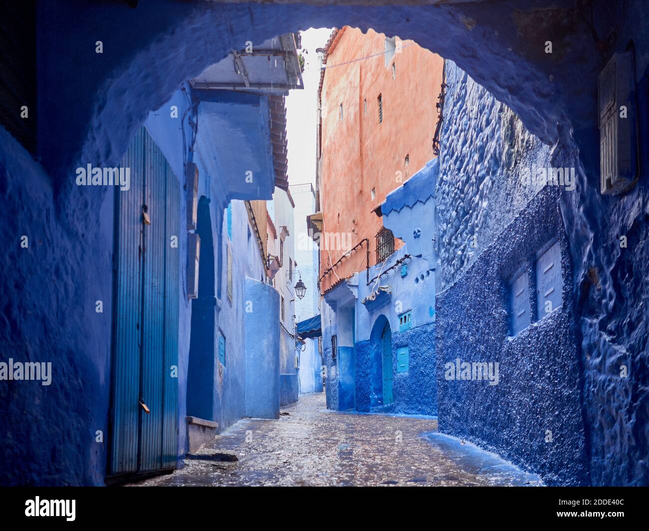 Marokko, Chefchaouen Provinz, Chefchaouen, Bogen von leerem Kopfsteinpflaster Gasse zwischen alten blauen Häusern Stockfoto