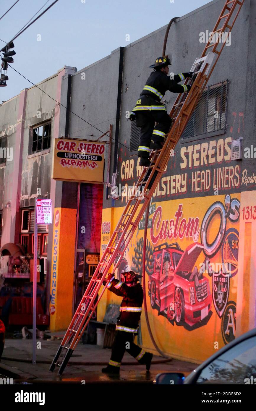 KEIN FILM, KEIN VIDEO, KEIN Fernsehen, KEINE DOKUMENTATION - ein Feuerwehrmann aus Oakland besteigt einen Letzteren, um einen tödlichen Brand zu vermessung, bei dem am Samstag, dem 3. Dezember 2016, bei einer Lagerfeier in der 31st Avenue in Oakland, CA, USA, mindestens neun Menschen ums Leben kamen. Foto von Ray Chavez/Bay Area News Group/TNS/ABACAPRESS.COM Stockfoto