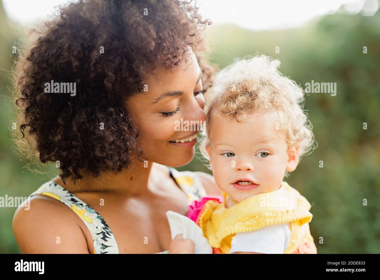 Mutter hält Baby Mädchen, während im Park stehen Stockfoto