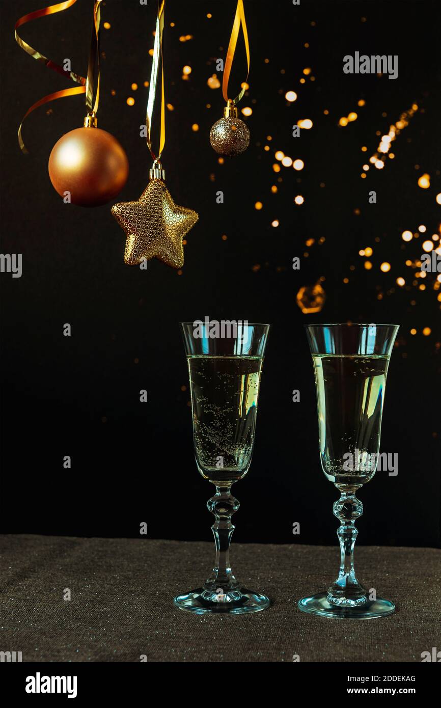 Zwei Gläser Champagner auf schwarzem Hintergrund mit weihnachtsschmuck, Nahaufnahme. Neujahrskonzept Stockfoto