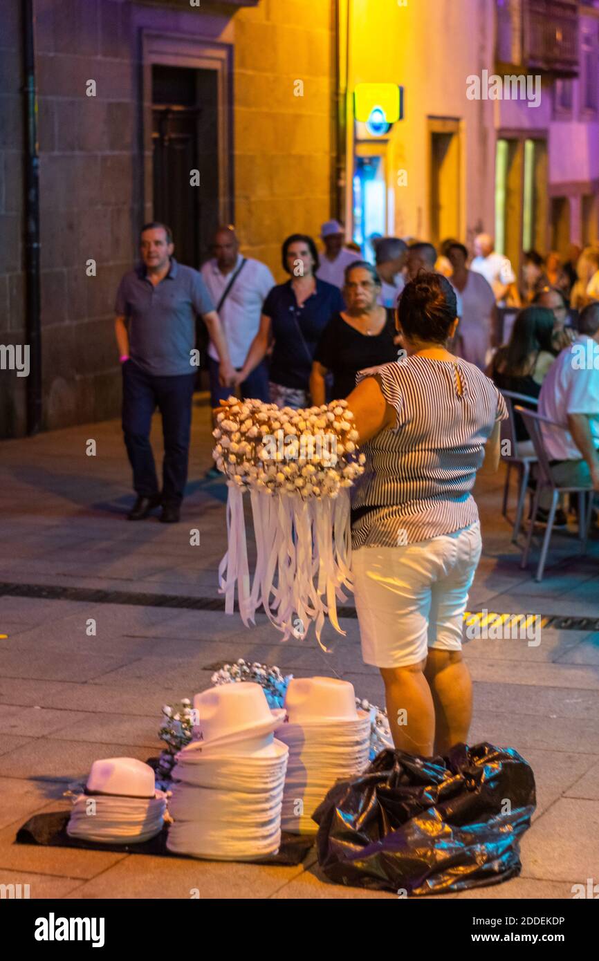 Straßenhändler, Frauen, die Blumen und Hüte für eine Veranstaltung in der Stadt Braga in Portugal verkaufen. Straßenverkäufer bei Nacht in den Städten. Stockfoto