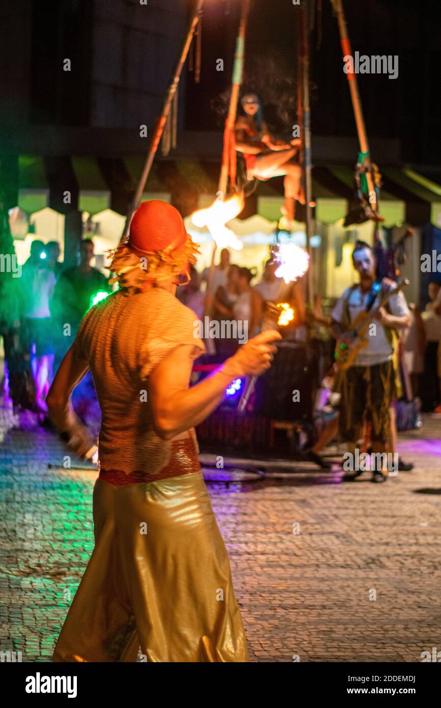 Straßenkünstler bewegen Zirkus mit Musikern und Feuerhandler. Live-Zirkus auf den Straßen der Stadt im Sommer für öffentliche Unterhaltung. Stockfoto