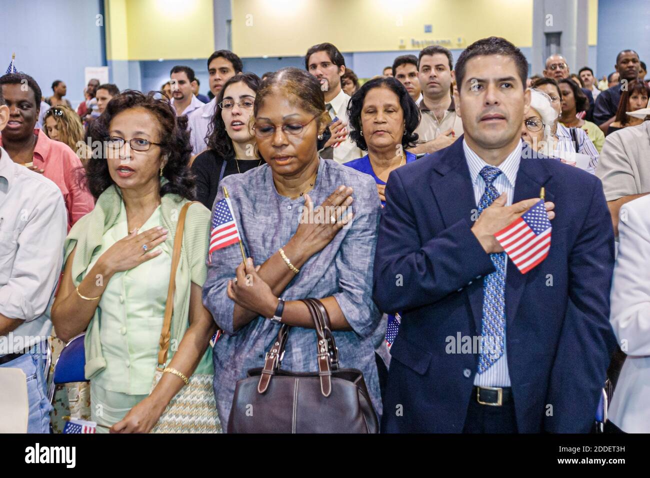 Miami Beach Florida, Einbürgerungszeremonie Eid der Staatsbürgerschaft, Einwanderer asiatische schwarze Frauen Mann rezitieren neuen Bürger mit Miniatur US-Flagge Stockfoto