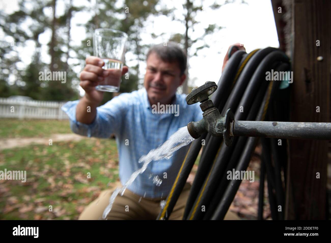 Albany, GA, USA. November 2020. Chad Holland, Albany, GA Hausbesitzer, der von Georgia Power Utility Praxis des Dumpings von Kohle Asche gefülltes Wasser in ungefütterten Siedlungsteich in der Nähe seines Hauses verärgert ist, dass kontaminierte Bereich Grundwasserversorgung.Bild: Holland prüft Wasser aus gut hinter seinem Haus Kredit: Robin Rayne/ZUMA Wire/Alamy Live News Stockfoto