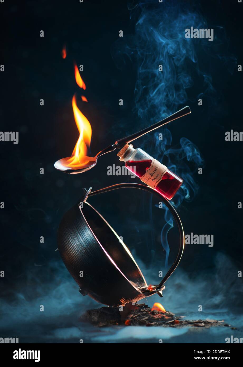 Kessel, Feuertrank und ein bald mit Flamme in einer ausgleichenden Komposition mit Rauch, Fantasy-Buchcover Stockfoto