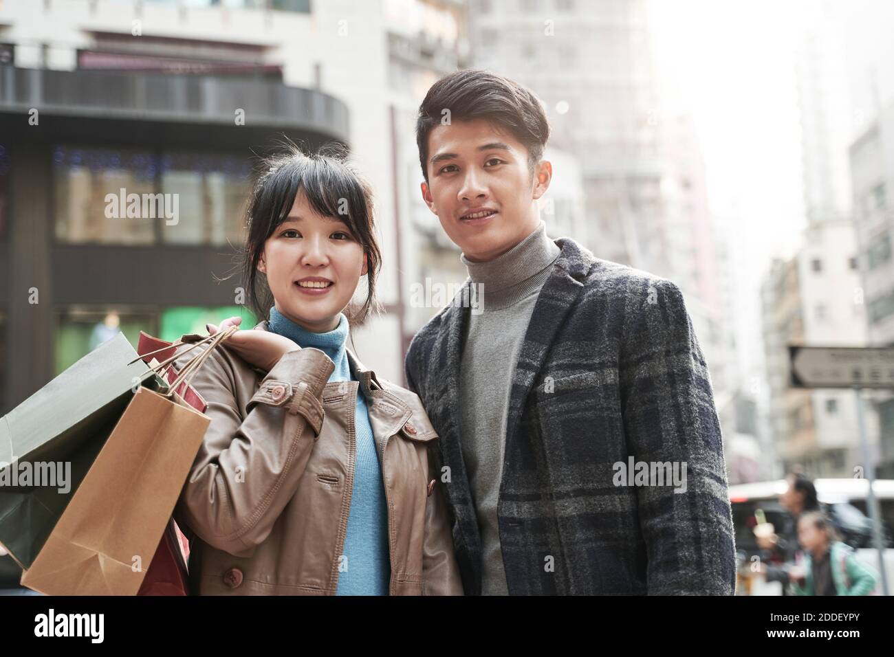 Outdoor-Porträt von glücklich junge asiatische Paar mit Einkaufstaschen Stockfoto