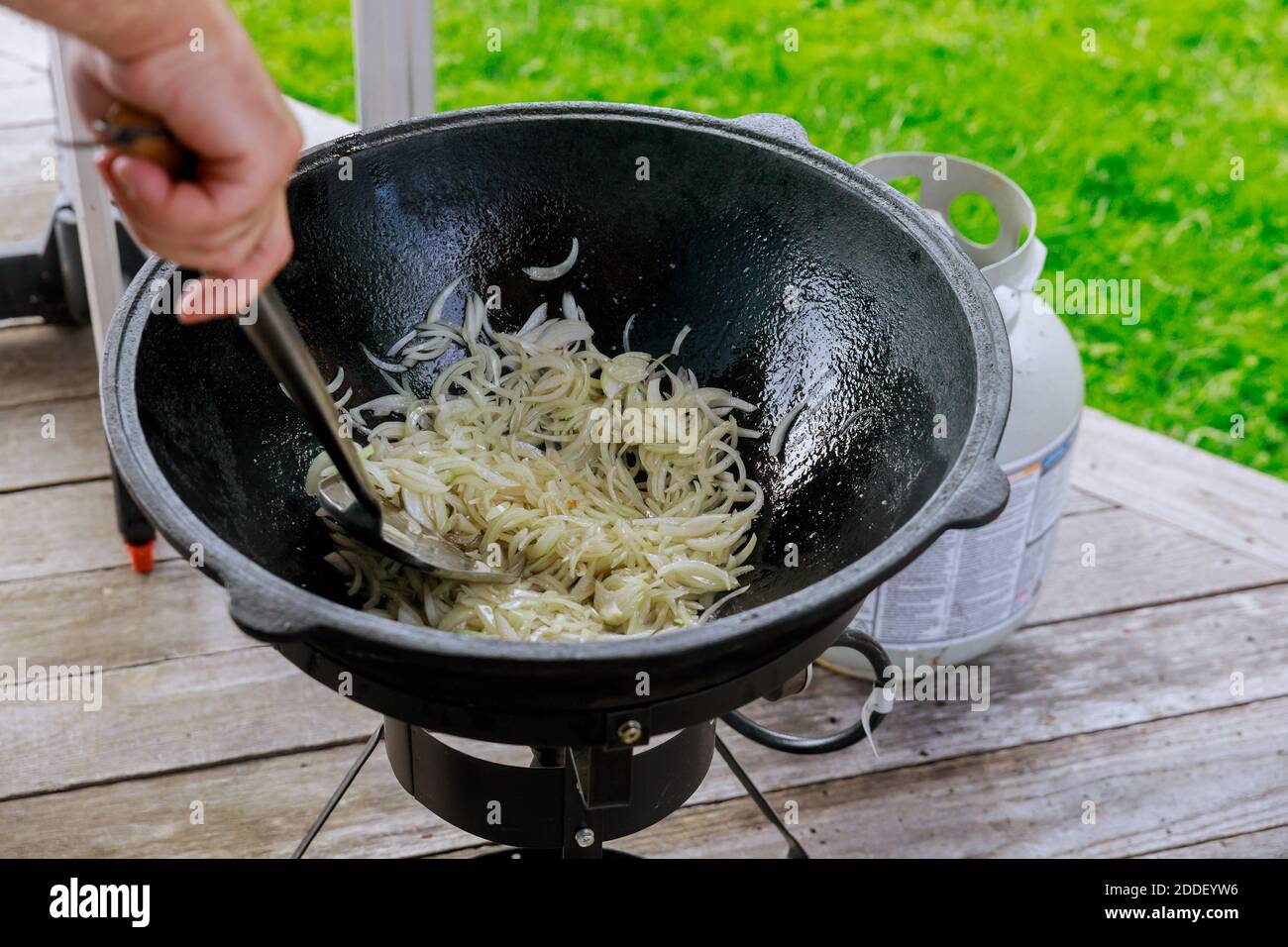 Man frittiert und dreht die Zwiebel im Kessel in Brand. Stockfoto