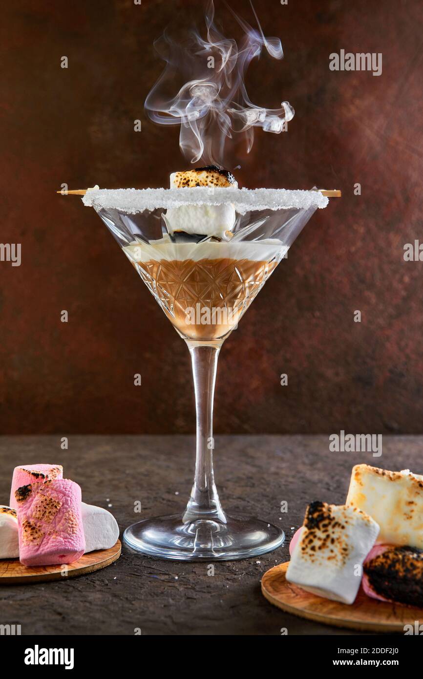 Irischer Cremelikör in einem martini-Glas mit Marshmallows mit Rauch. Stockfoto