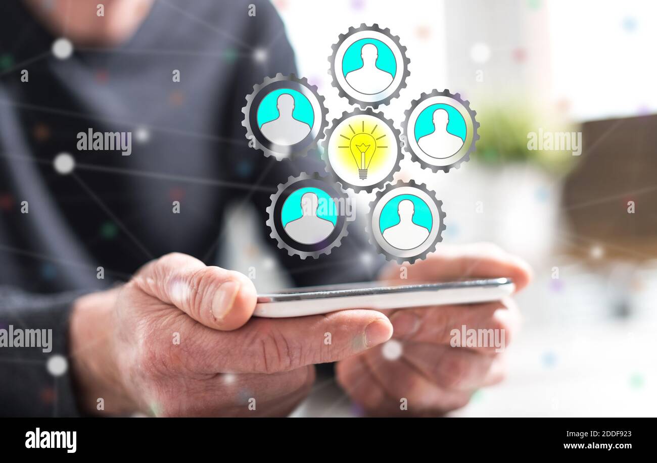 Hände des Mannes hält ein Smartphone mit Teamwork Idee Konzept Stockfoto