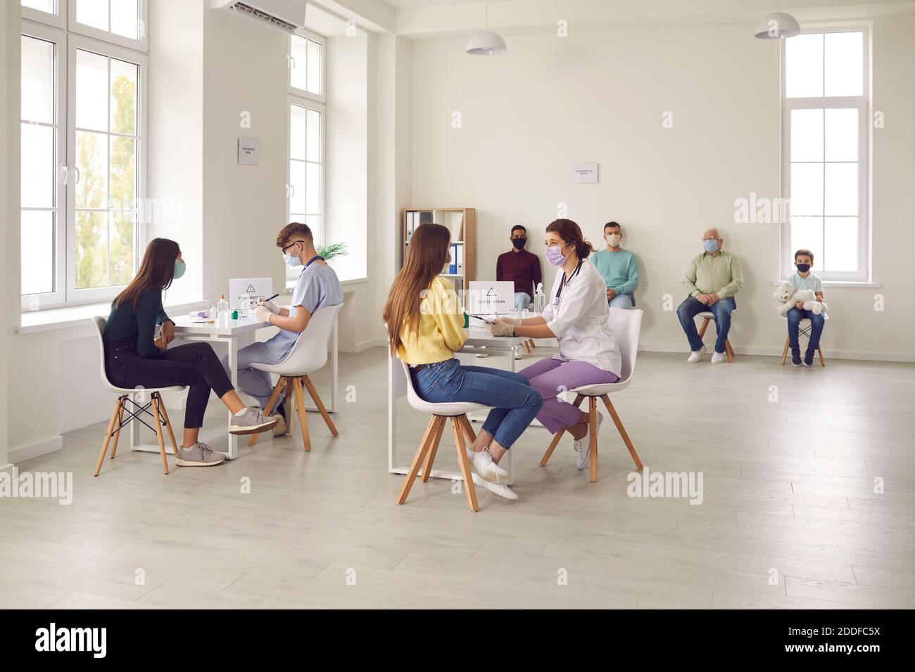 Verschiedene Menschen sprechen mit Ärzten, bevor sie eine antivirale Injektion Im Krankenhaus Stockfoto