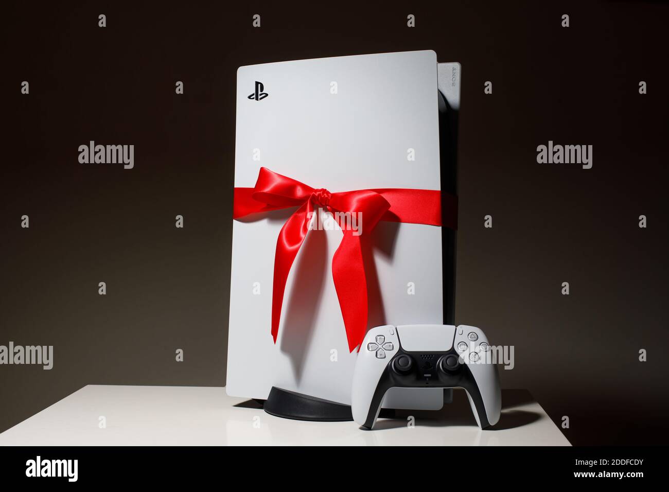 Sony PlayStation 5 Spielkonsole auf schwarzem Hintergrund. Geschenkausgabe mit rotem Band schwarz freitag und Weihnachten Deal Stockfoto
