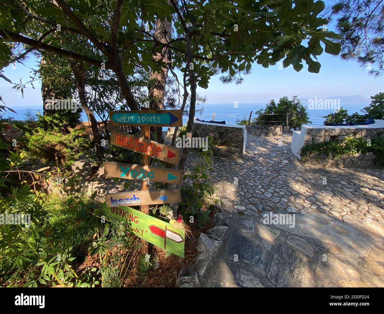 Ziemlich handgemachte Outdoor-Beschilderung zeigt verschiedene Routen und Richtungen für Massage, Yoga, Strand, Wassersport. Stockfoto