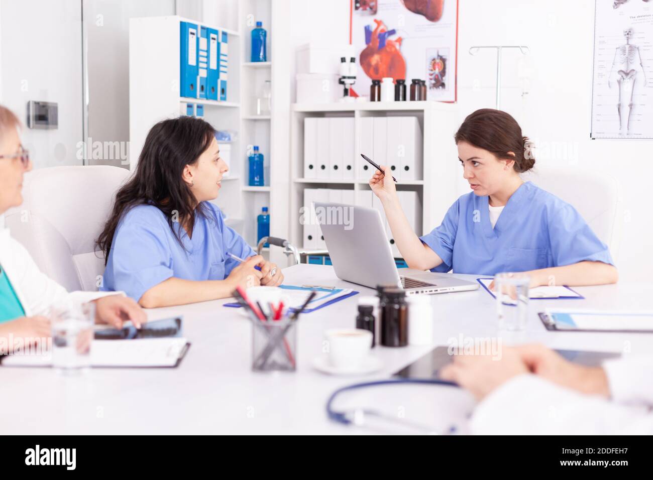 Medizinische Krankenschwestern tun Teamarbeit tragen blaue Uniform während der akademischen medizinischen Konferenz. Kliniktherapeut mit Kollegen reden über Krankheit, Experte, Spezialist, Kommunikation. Stockfoto