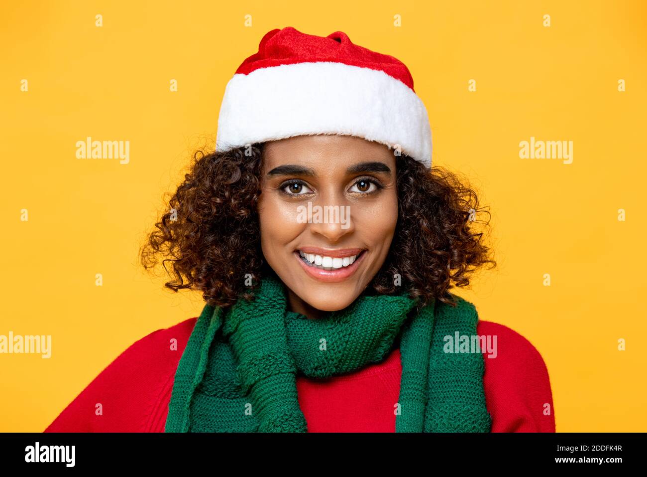 Nahaufnahme Porträt der hübschen Frau in Weihnachtskleidung lächelnd Und Blick auf die Kamera auf isolierten bunten gelben Hintergrund Stockfoto