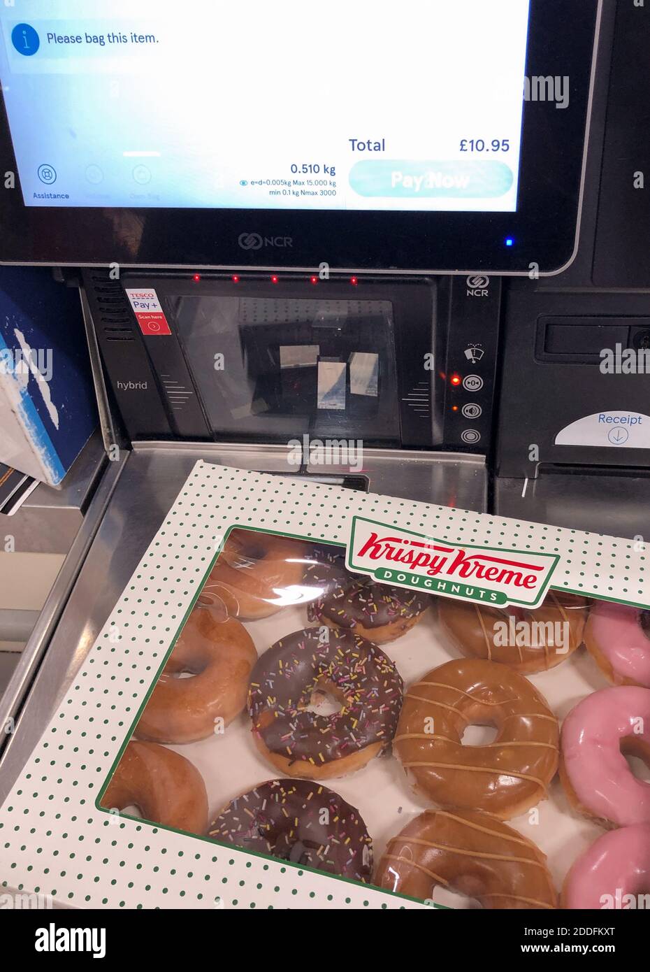 Eine Kiste Krispy Kreme Donuts an der Selbstbedienungskasse in einem Tesco Extra-Geschäft in Wisbech, Cambridgeshire. Cambridgeshire Polizist Simon Read wird vor der Anklage zu versuchen, eine £9.95 Box mit 12 Krispy Kreme Donuts für sieben Pence durch Ankleben eines Barcodes für Karotten auf sie und gehen durch eine Self-Service-Kasse im Tesco Extra-Shop kaufen. Stockfoto