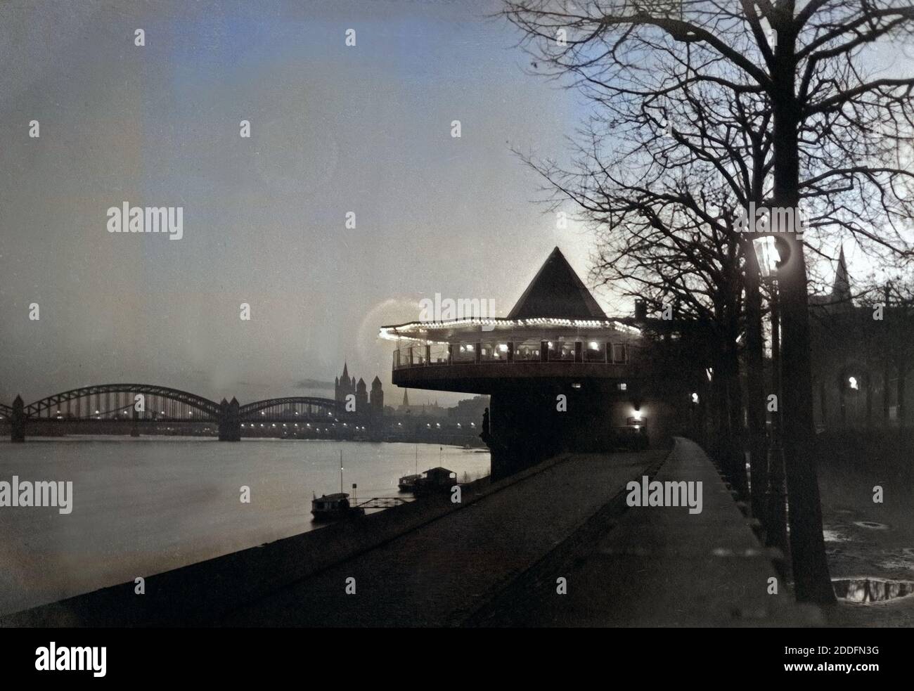 Blick Auf sterben Bastel, sterben Hohenzollernbrücke Und Die Altstadt Mit der Kirche Groß St. Martin bin Rheinufer Bei Nacht in Köln, Deutschland 1920er Jahre. Blick auf Restaurant Bastei, Hohenzollernbruecke Brücke, alte Stadt mit grober St.-Martins Kirche mit Rhein in Köln der 1920er Jahre. Stockfoto