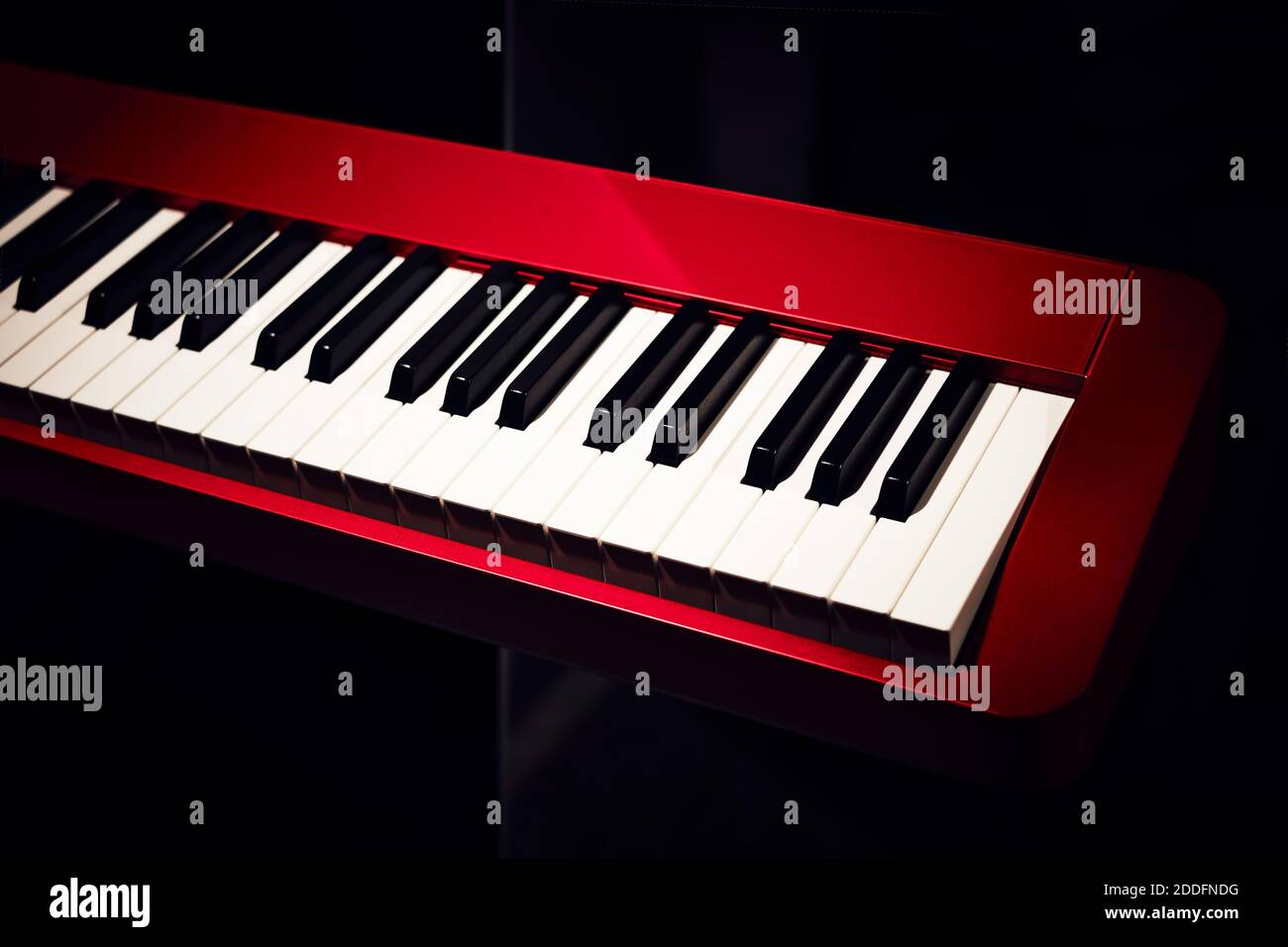 Elektronischer Synthesizer (Klaviertastatur) Nahaufnahme mit dunklem Hintergrund. Schöne rote Musiktastatur mit Balck und weißen Tasten. Stockfoto
