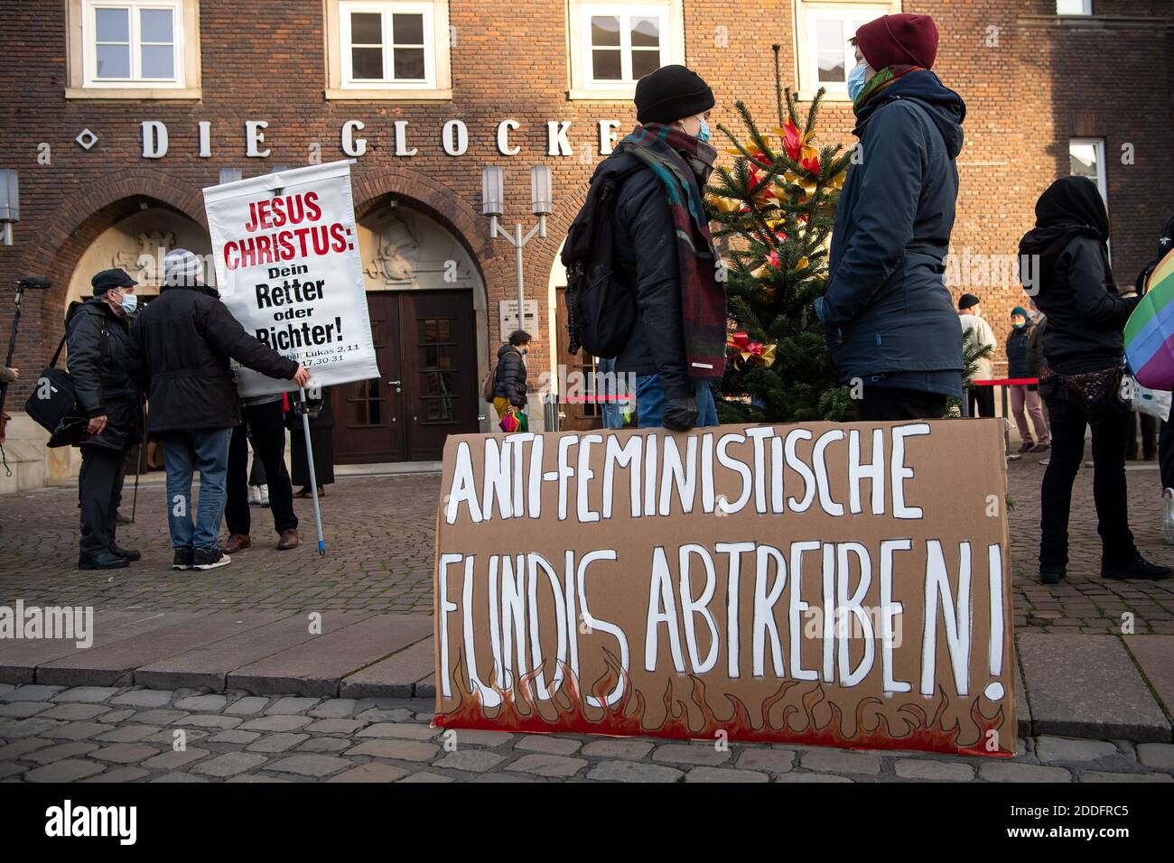 Bremen, Deutschland. November 2020. Vor dem Gebäude "The Bell", wo der Prozess gegen einen Pastor stattfindet, halten Demonstranten Plakate mit der Aufschrift "Abbrechen anti-feministischen fundis!" (r) und "Jesus Christus: Dein Retter oder Richter!" Dem protestantischen Pastor Latzel wurde vorgeworfen, in einem ebenfalls auf YouTube ausgestrahlten Eheeminar mit abwertenden Aussagen über Homosexualität Hass geschürt zu haben. Das Bezirksgericht Bremen verurteilte ihn zu einer Geldstrafe wegen Gutschrift: Sina Schuldt/dpa/Alamy Live News Stockfoto