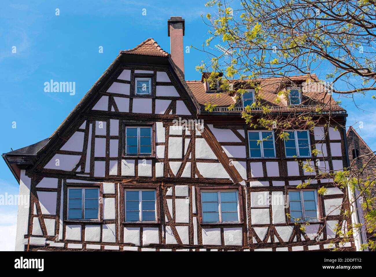 Natürliches Fachwerkhaus in Frankreich, Straßburg. Fachwerkstil. Fassade des historischen Holzgebäudes während des sonnigen Frühlingstages. Stockfoto
