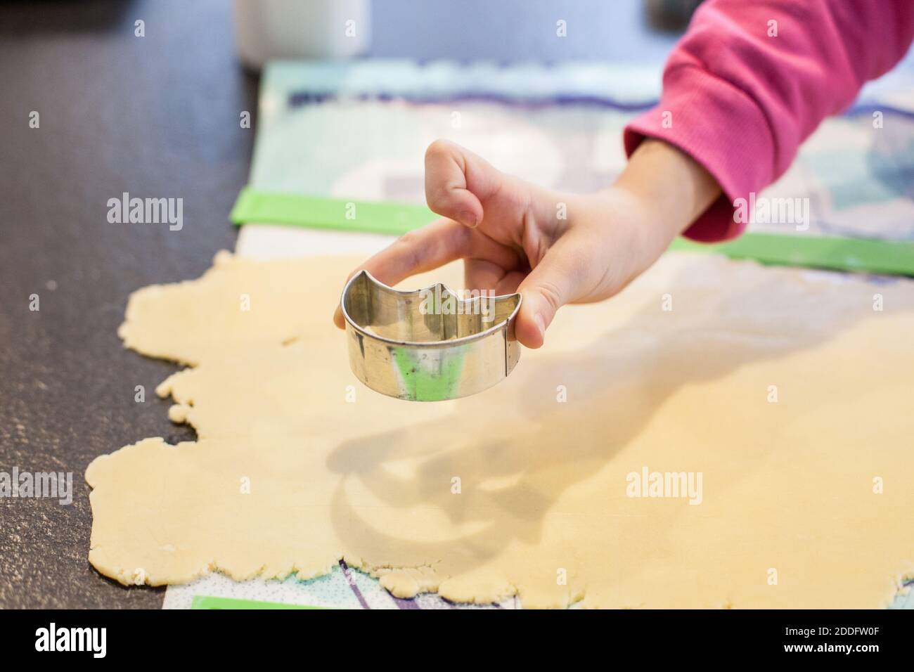 Bamberg, Deutschland 22. November 2020: Symbolbilder - 2020 - aus dem hausgemachten Teig, der auf einer Oberfläche ausgerollt wird, schneidet eine Kinderhand mit einem Cutter Kekse aus. Weltweite Nutzung Stockfoto