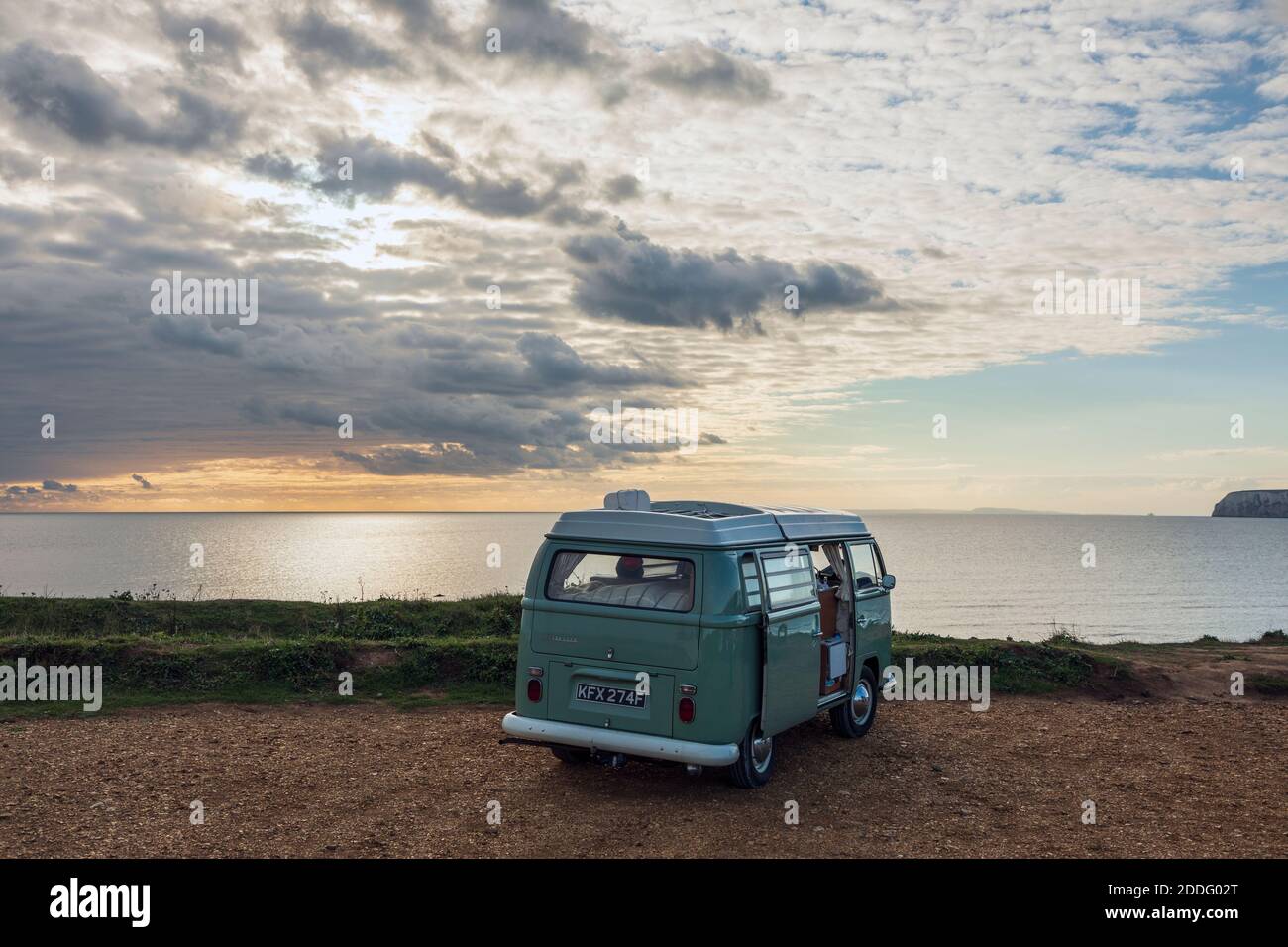 Ein klassischer VW-Wohnmobil, der bei Sonnenuntergang in der Compton Bay auf der Isle of Wight geparkt ist Stockfoto