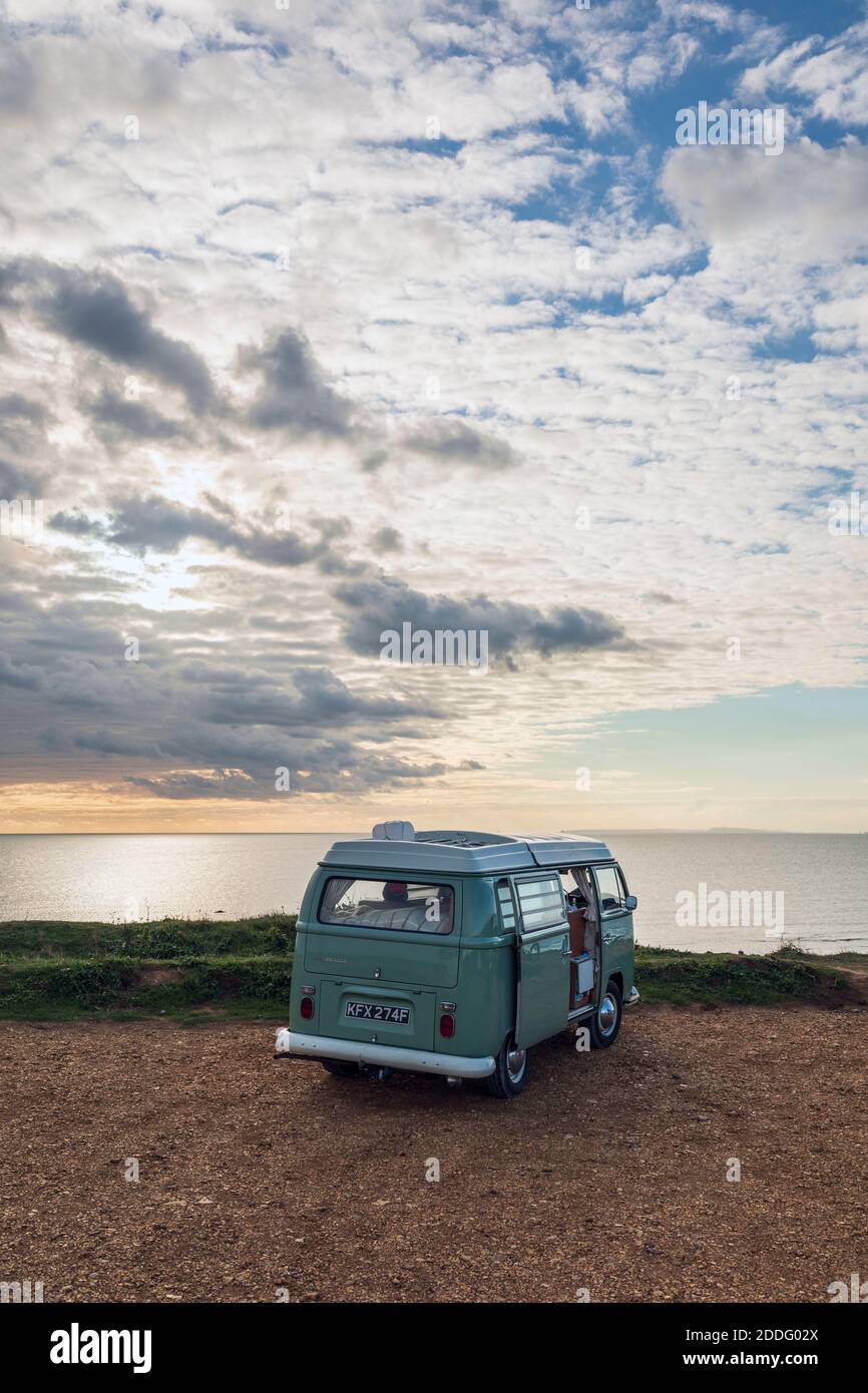 Ein klassischer VW-Wohnmobil, der bei Sonnenuntergang in der Compton Bay auf der Isle of Wight geparkt ist Stockfoto