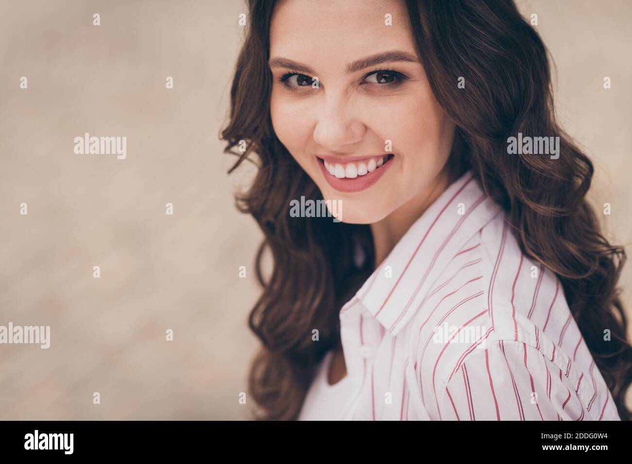 Zugeschnittenes Porträt-Foto von hübschen weiblichen Studenten lächelnd tragen weiß hemd lange braune Lockenfrisur Stockfoto