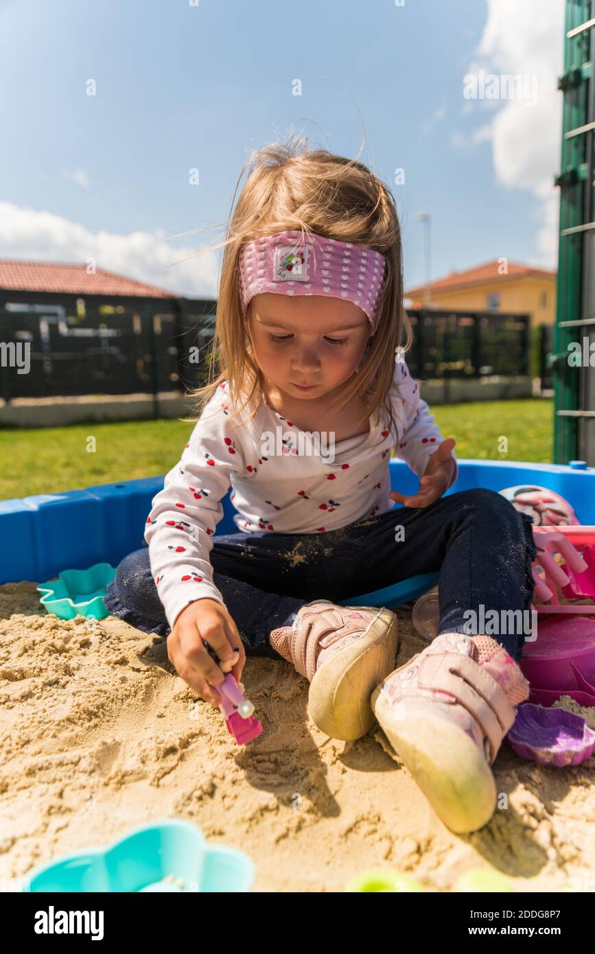 Fokussiertes Kind spielt im Sandkasten, im Freien Stockfoto