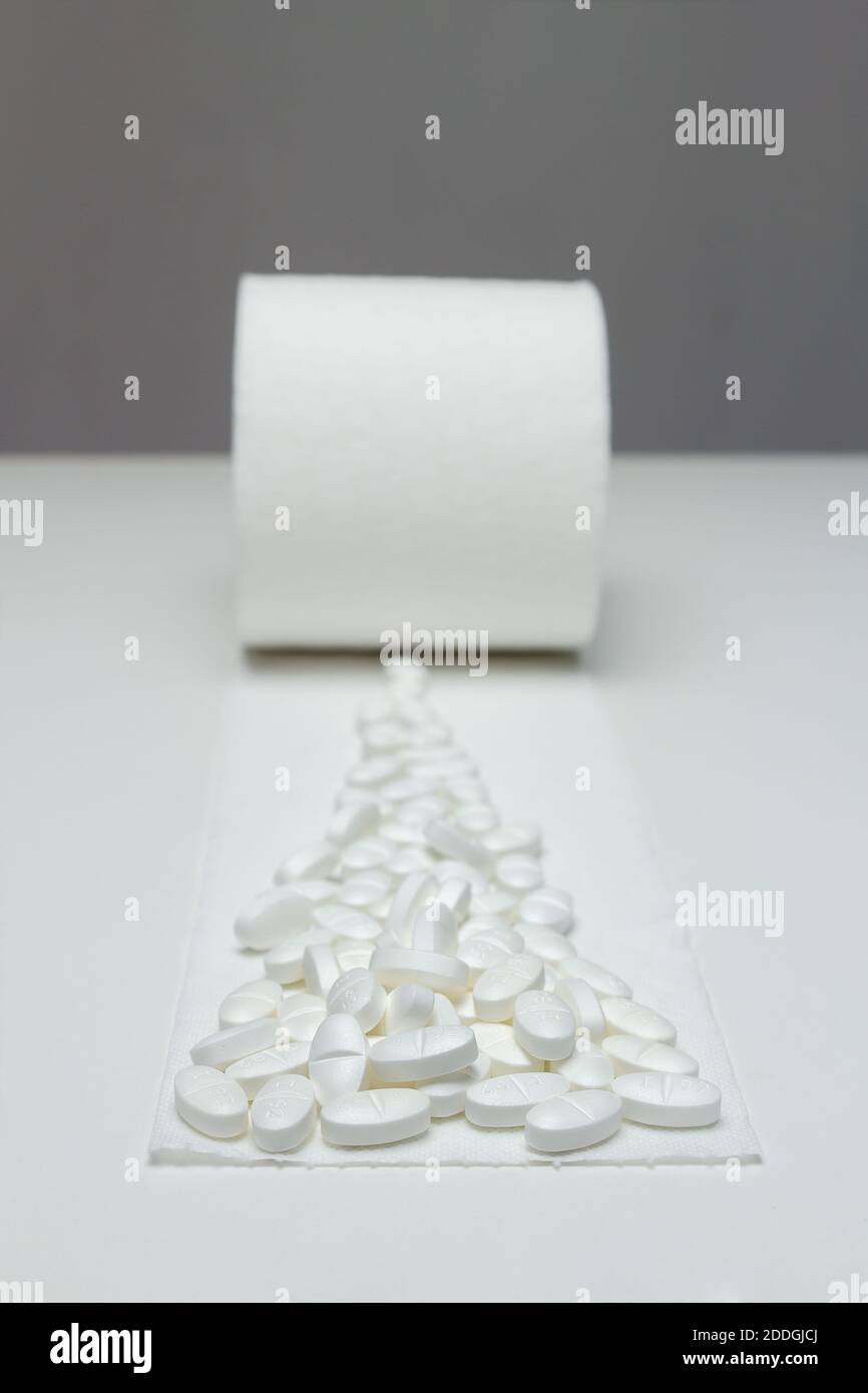 Nicht gerollte Toilettenpapierrolle mit einer Spur von Pillen. Behandlung von Magen- und Darmproblemen, Verstopfung mit Abführmitteln und Pillen. Medizin. Stockfoto