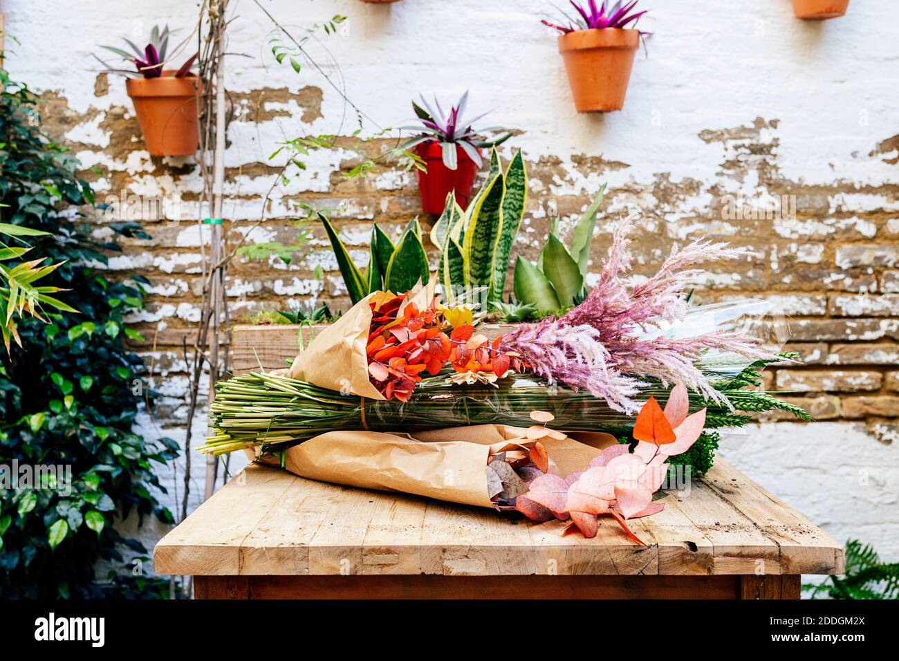 Holztisch in Floristik Werkstatt voller Blumen für Arrangements Stockfoto