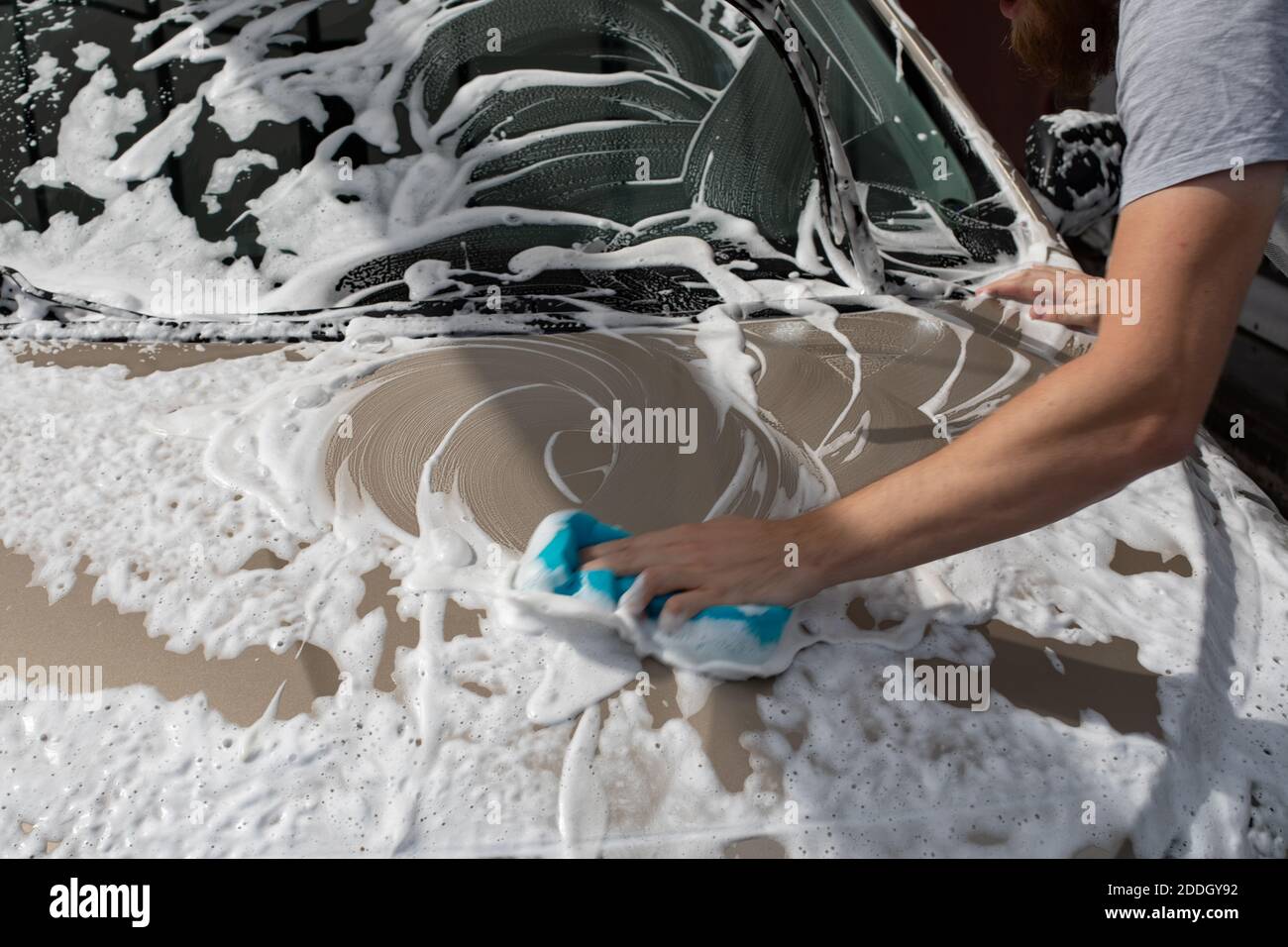 Mann Wasch Auto Haube mit Waschlappen und Shampoo, Auto bedeckt mit Schaum,  Auto waschen Service Stockfotografie - Alamy