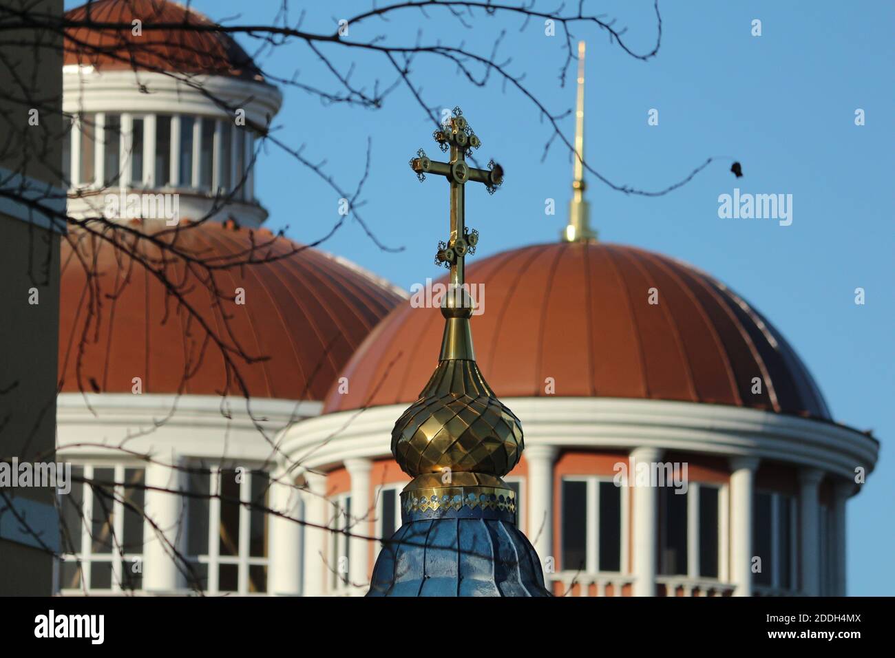 Orthodoxe Kreuz aus gelbem Metall auf der Kuppel der orthodoxen Kirche. Die metallene gelbe Goldkuppel der orthodoxen Kirche mit einem Kreuz. Stockfoto