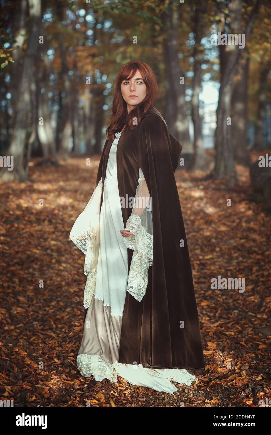 Schöne mittelalterliche Frau in einem dunklen Herbstwald Stockfoto