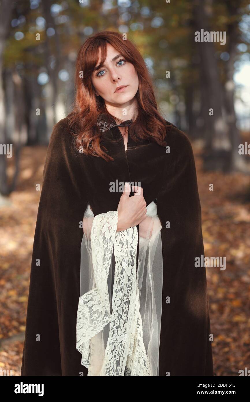 Schöne mittelalterliche Frau mit braunem Mantel. Herbstwald Stockfoto