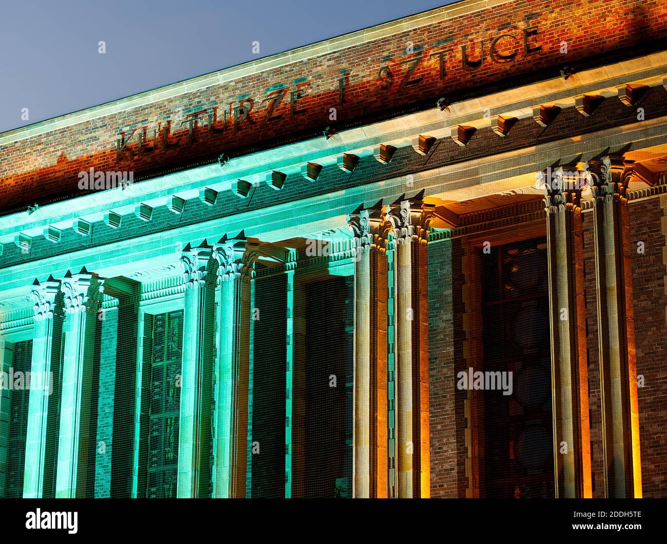 Fragment eines Palastes der saglebischen Kultur in Dabrowa Gornicza mit Pylonen in grünem und rotem Licht. Übersetzung für die Inschrift auf einem Gebäude: 'Für den Kult Stockfoto